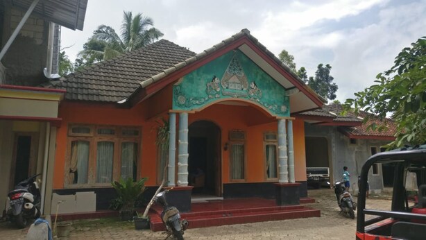 A two-story building with a traditional architectural style, featuring a prominent entrance with a decorative archway and a tiled roof. - Pringsewu Craft Homestay - Hostel (Muntuk)