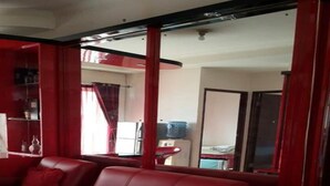 Een rode leren bank in een kamer met een betegelde vloer en een rood gordijn.