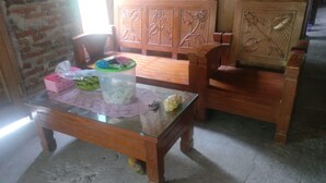 A dining table with a glass top, surrounded by wooden chairs. - Arnymas Homestay Syariah (Bantul)