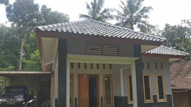 A modern two-story house with a tiled roof, a covered porch, and a garage. - Elvira Homestay - Hostel (Muntuk)