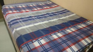 A single bed with a plaid bedspread and a headboard. - Elvira Homestay - Hostel (Muntuk)