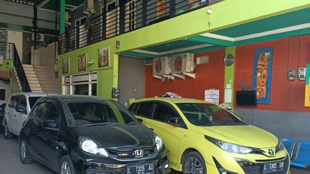 Un concesionario de automóviles con dos coches estacionados al frente.