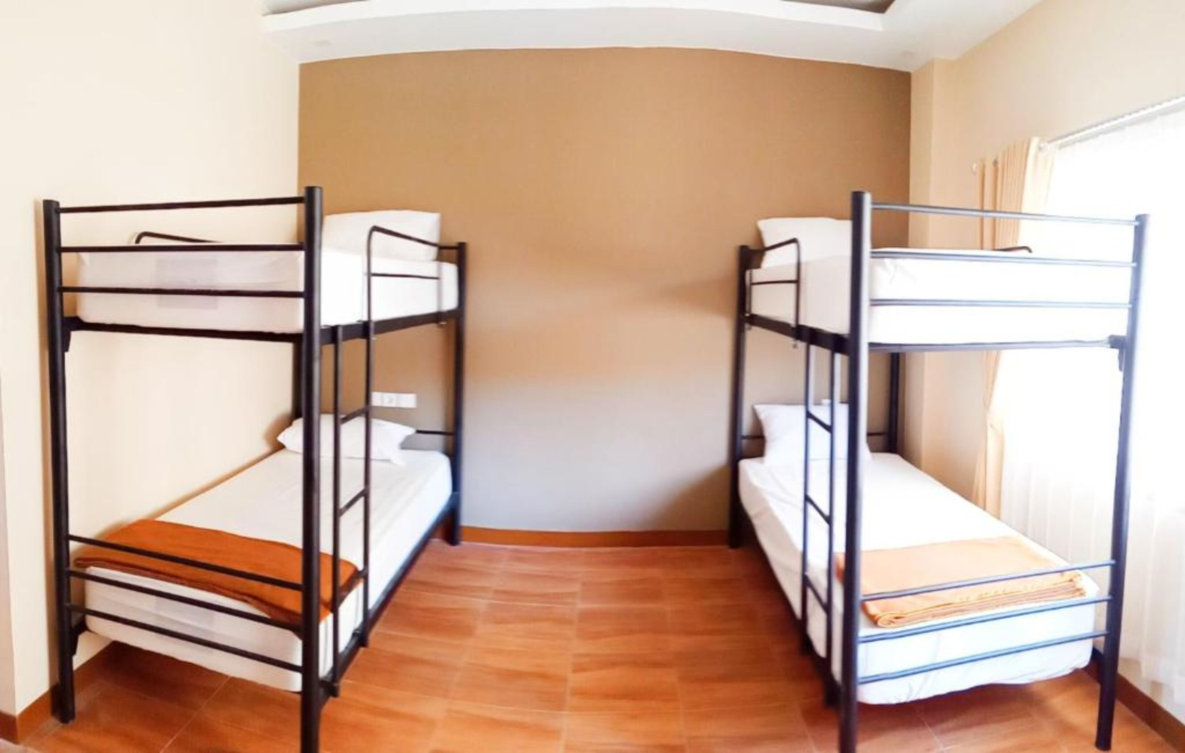 A room with two bunk beds, a tiled floor, and a curved ceiling.