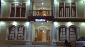 A hotel with a central entrance, a balcony with ornate railings, and a sign reading "Bluefire". - Bluefire Homestay Syariah (Banyuwangi)
