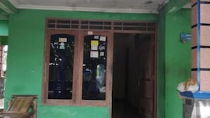 A building with a green exterior, a tiled entrance, and a wooden bench outside. - Abimanyu Homestay (Imogiri)