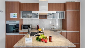 A modern kitchen with wooden cabinets, stainless steel appliances, and a granite countertop. - Art apartment (Locarno)