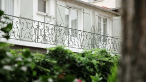 Un edificio blanco con un balcón que presenta barandillas de hierro forjado decorativas.