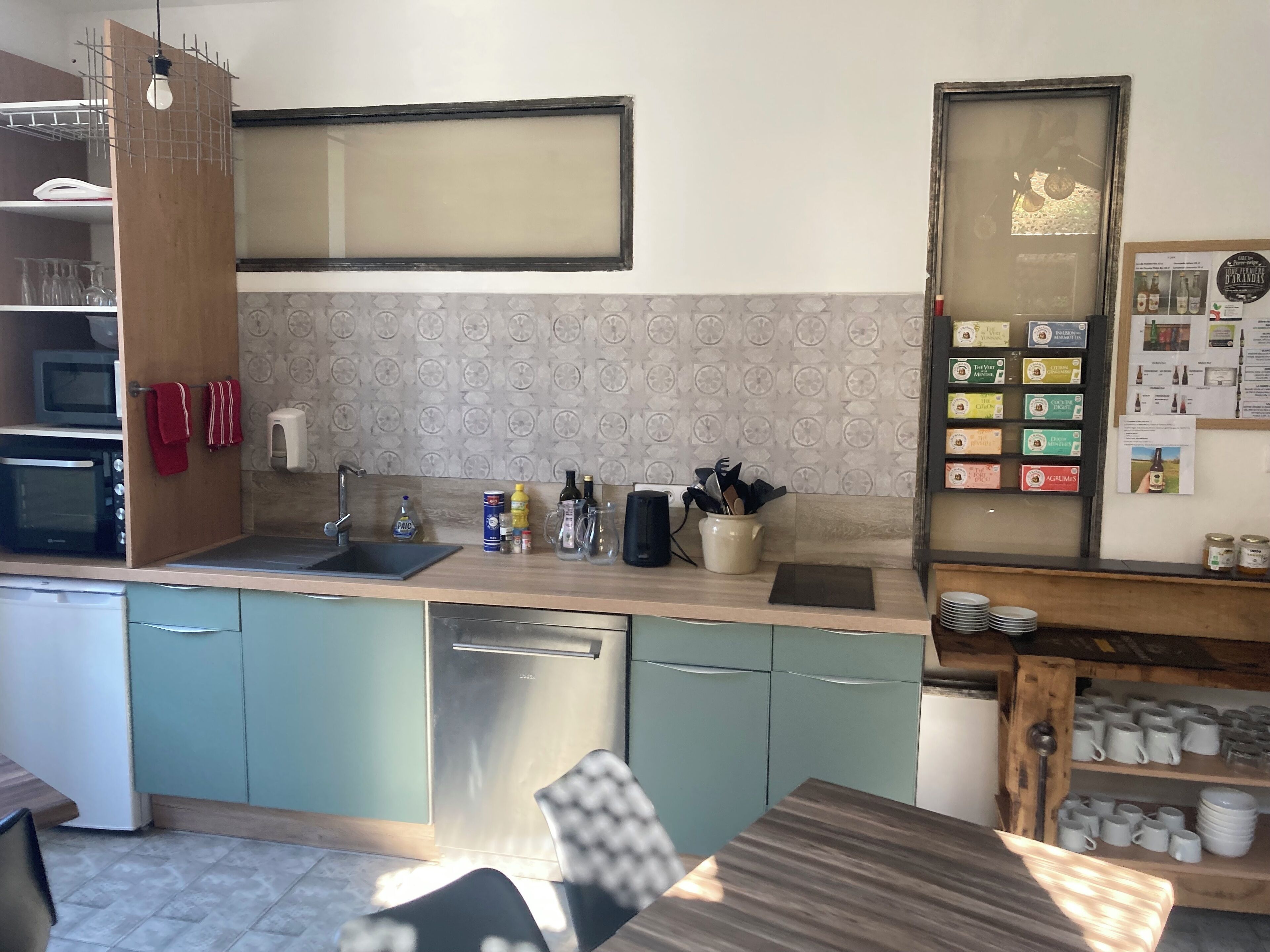 A modern kitchen with a wooden countertop, stainless steel appliances, and a tiled backsplash.