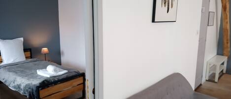 Une chambre à coucher moderne avec un lit, une table de chevet et un canapé gris.