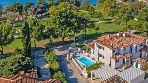 A coastal property with a swimming pool, a lighthouse, and a view of the sea.