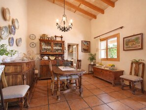 A traditional dining room with a wooden table, chairs, and a chandelier.