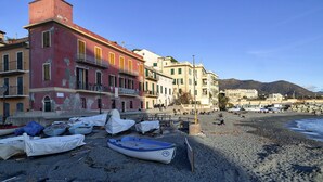 A beach with boats and buildings in the background. - Sapore di Sale by Wonderful Italy (Genoa)