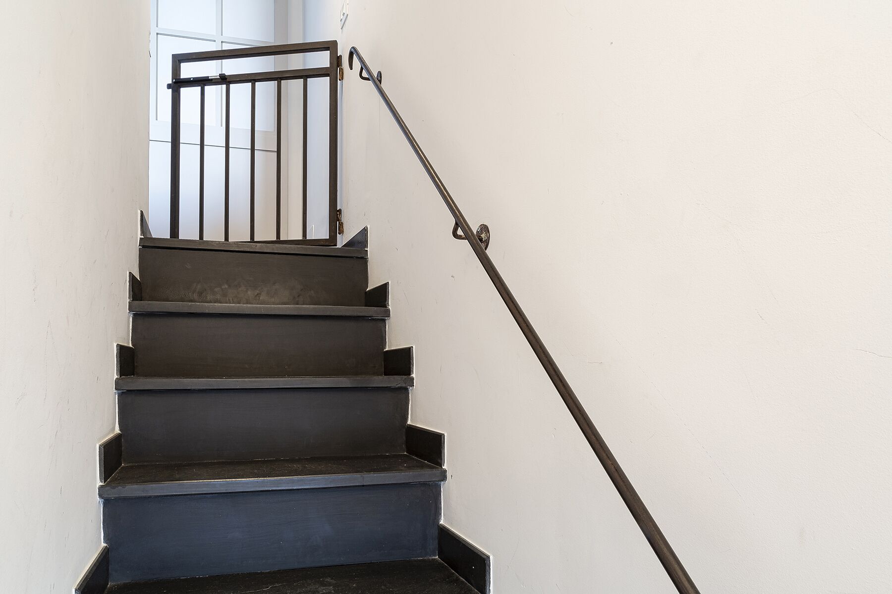 A staircase with metal railings and a handrail.