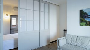 A modern bedroom with a sliding closet door, a bed, and a painting on the wall. - Sapore di Sale by Wonderful Italy (Genoa)