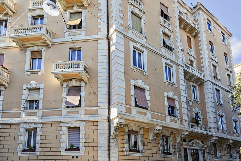 A multi-story building with balconies, large windows, and decorative architectural details.