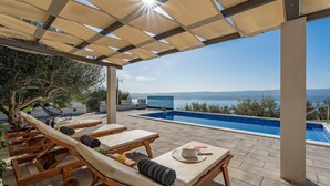 A rooftop pool area with sun loungers and a view of the sea. - Villa Dream with private pool, 2 bedrooms with en-suite bathrooms, sea view (Omis)