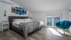 A bedroom with a bed, a nightstand, a chair, and a large window with a view. - Villa Dream with private pool, 2 bedrooms with en-suite bathrooms, sea view (Omis)