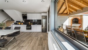 A modern kitchen with white cabinets, a stainless steel refrigerator, and a dining area with a glass table and chairs. - Villa Dream with private pool, 2 bedrooms with en-suite bathrooms, sea view (Omis)