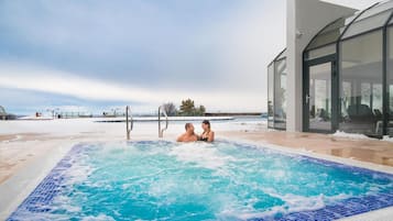 Una piscina techada, una piscina al aire libre de temporada, sombrillas