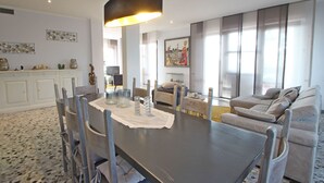A modern dining area with a dark wooden table, white chairs, and a central light fixture. - Wonderful  villa for 6 people with WIFI, TV, terrace and panoramic view, close to Forte Dei Marmi (Marina Dei Ronchi)