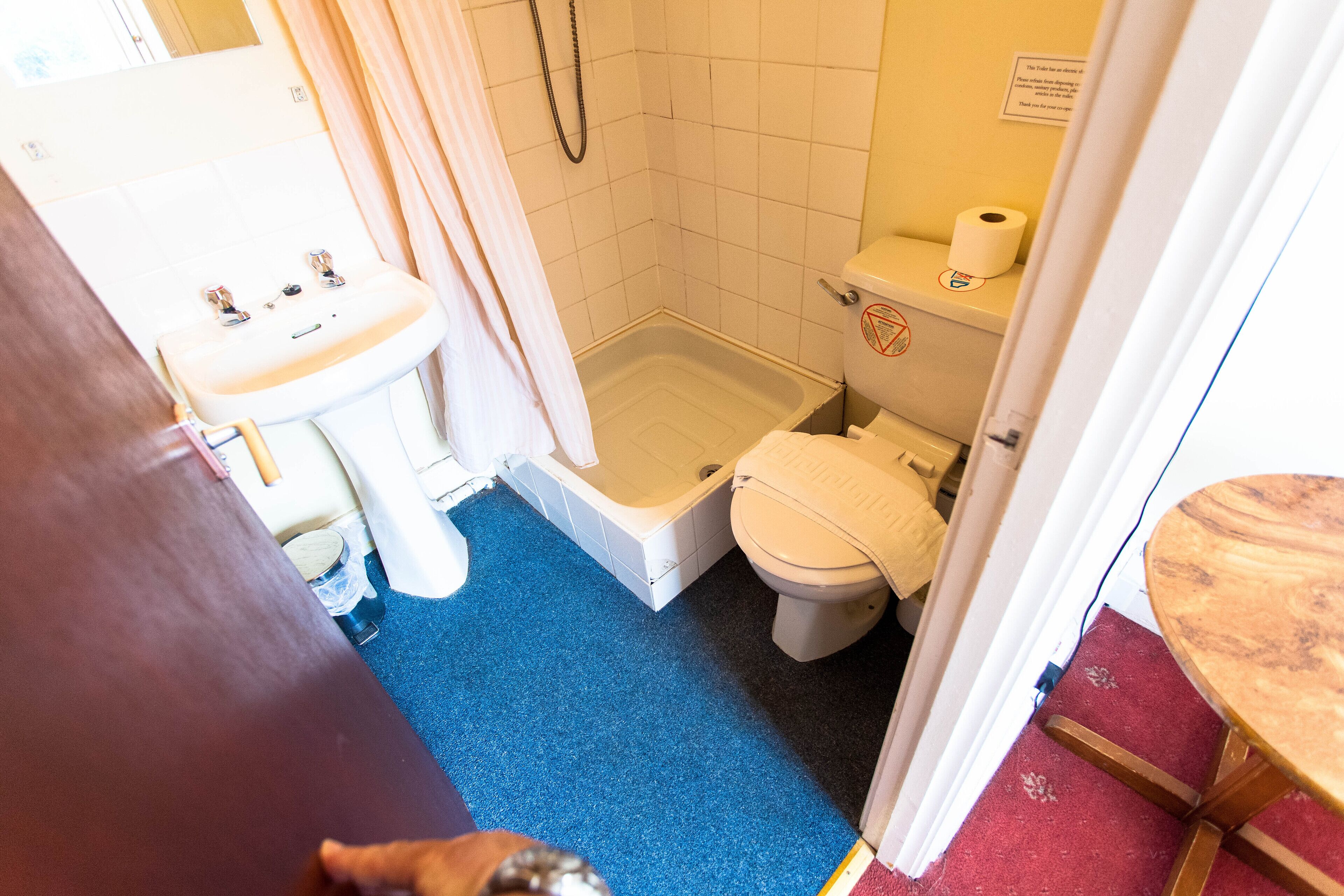 A bathroom with a shower, toilet, and sink.