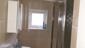A bathroom with a shower, a sink, and a window. - Apartment in london 2 minute walk to metro, near Stratford 

 (London)
