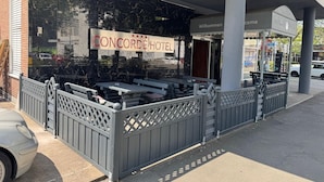 Ein Concorde Hotel mit Außenbestuhlung und überdachtem Eingang.