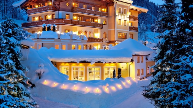 A large, multi-story hotel with a snow-covered exterior and warm interior lighting. - Apartment in Kleinarl Near Ski Slopes (Kleinarl)