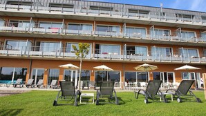 Ein mehrstöckiges Hotel mit Balkonen, Außenbereich und einem Schwimmbad.