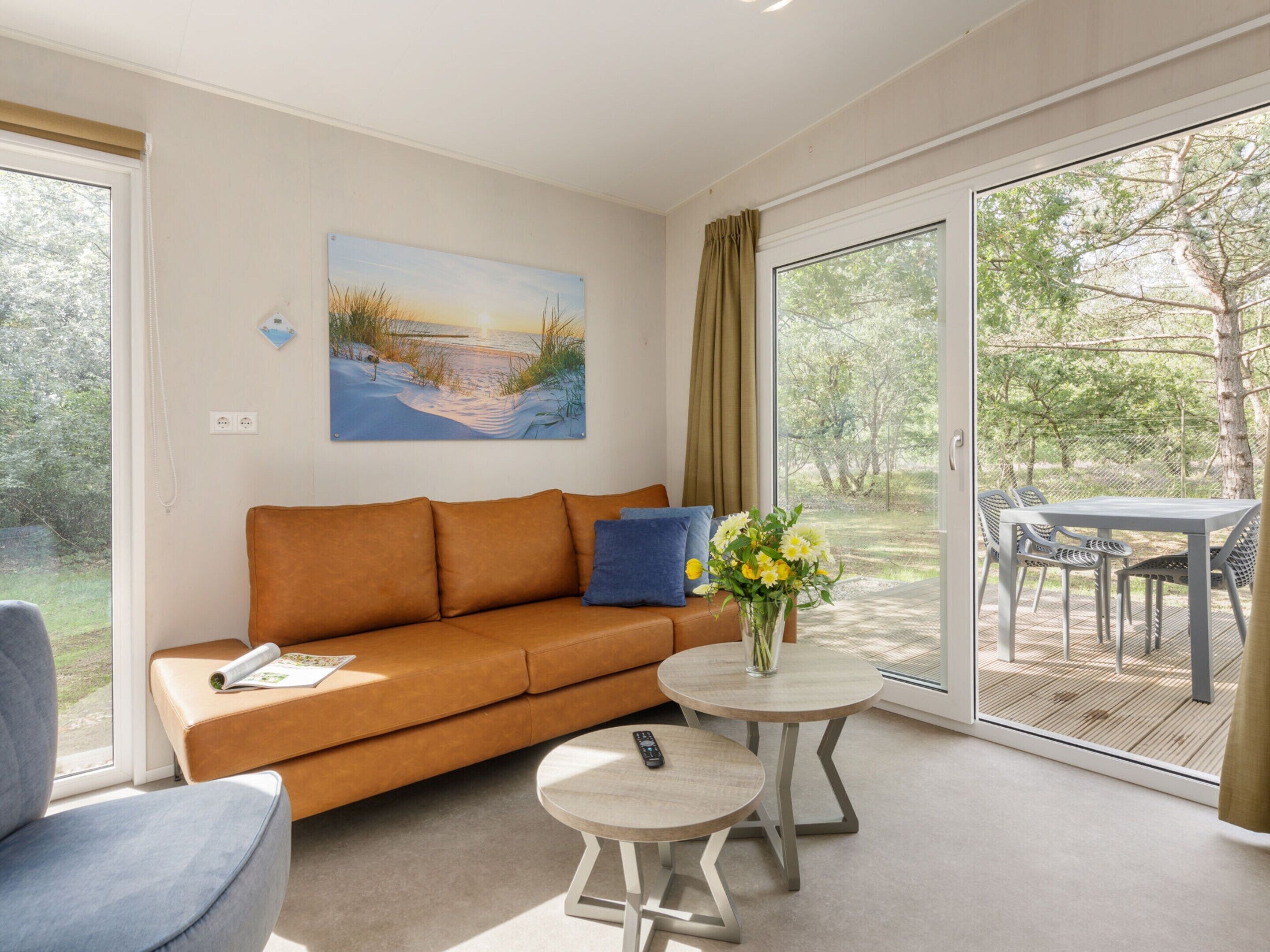 A modern living room with a sofa, a small round table, and a painting on the wall.