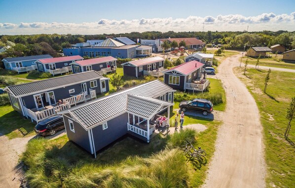 Ett bostadsområde med flera hus, en grusväg och en cykel.