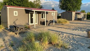 Two small, single-story cabins with attached porches, each with a bench and a table. - Chalet Near Loonse and Drunense Duinen (Udenhout)