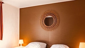 A hotel room with two beds, a large mirror, and a nightstand with a lamp. - Holiday Home With Terrace in Giethoorn (Giethoorn)