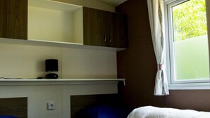 A bedroom with a bunk bed, a bedside table with a lamp, and a window with curtains. - Chalet Near Loonse and Drunense Duinen (Udenhout)
