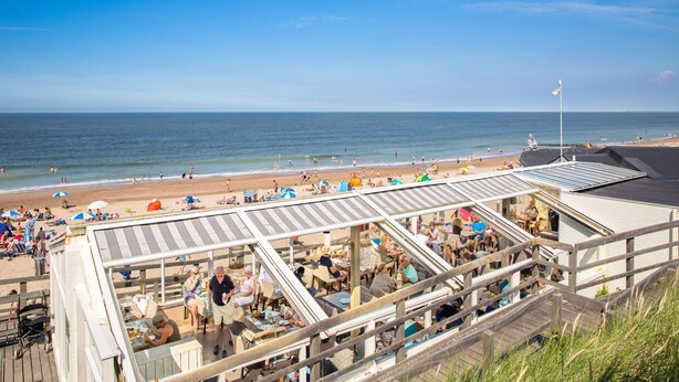 A beachside restaurant with outdoor seating overlooking the ocean. - Apartment in Domburg Near Sandy Beaches (Domburg)