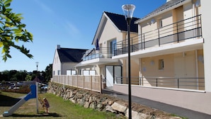 A modern building with a balcony, a play area, and a street lamp. - Apartment in Bretagne Near Morbihan (Baden)