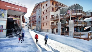 A multi-story building with a ski lift, wooden balconies, and a sign reading 'Super-Chatel.' - Central Chatel Getaway (Chatel)