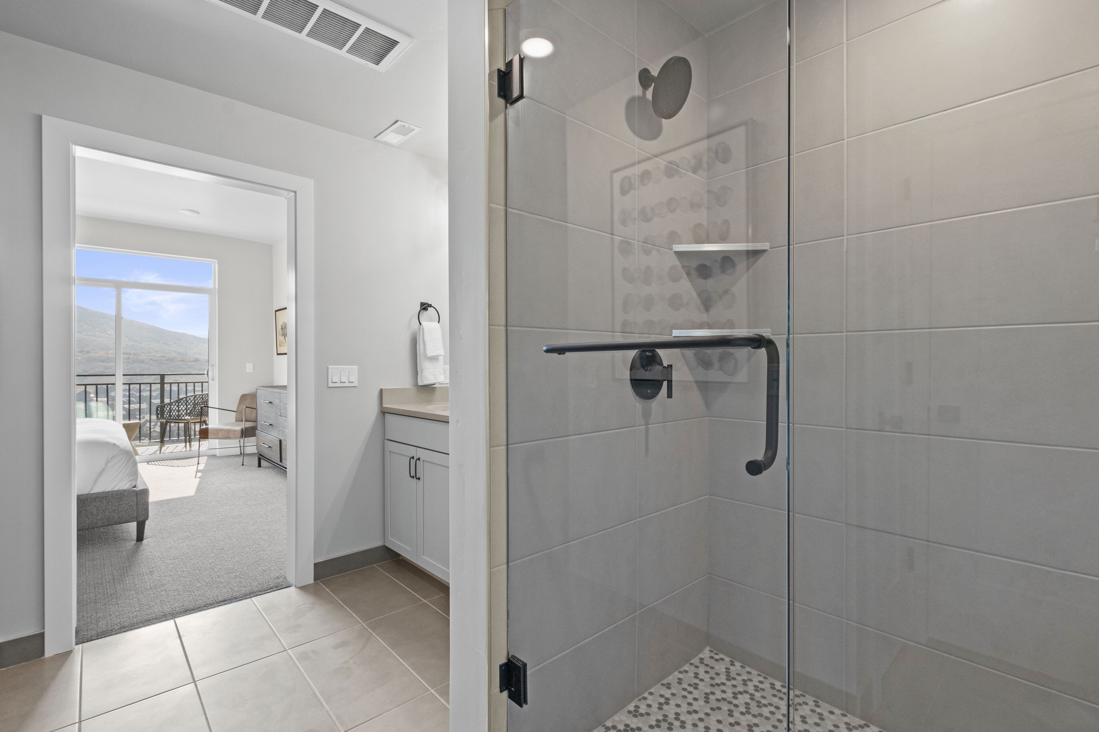 A modern bathroom with a glass shower enclosure, a towel rack, and a toilet.