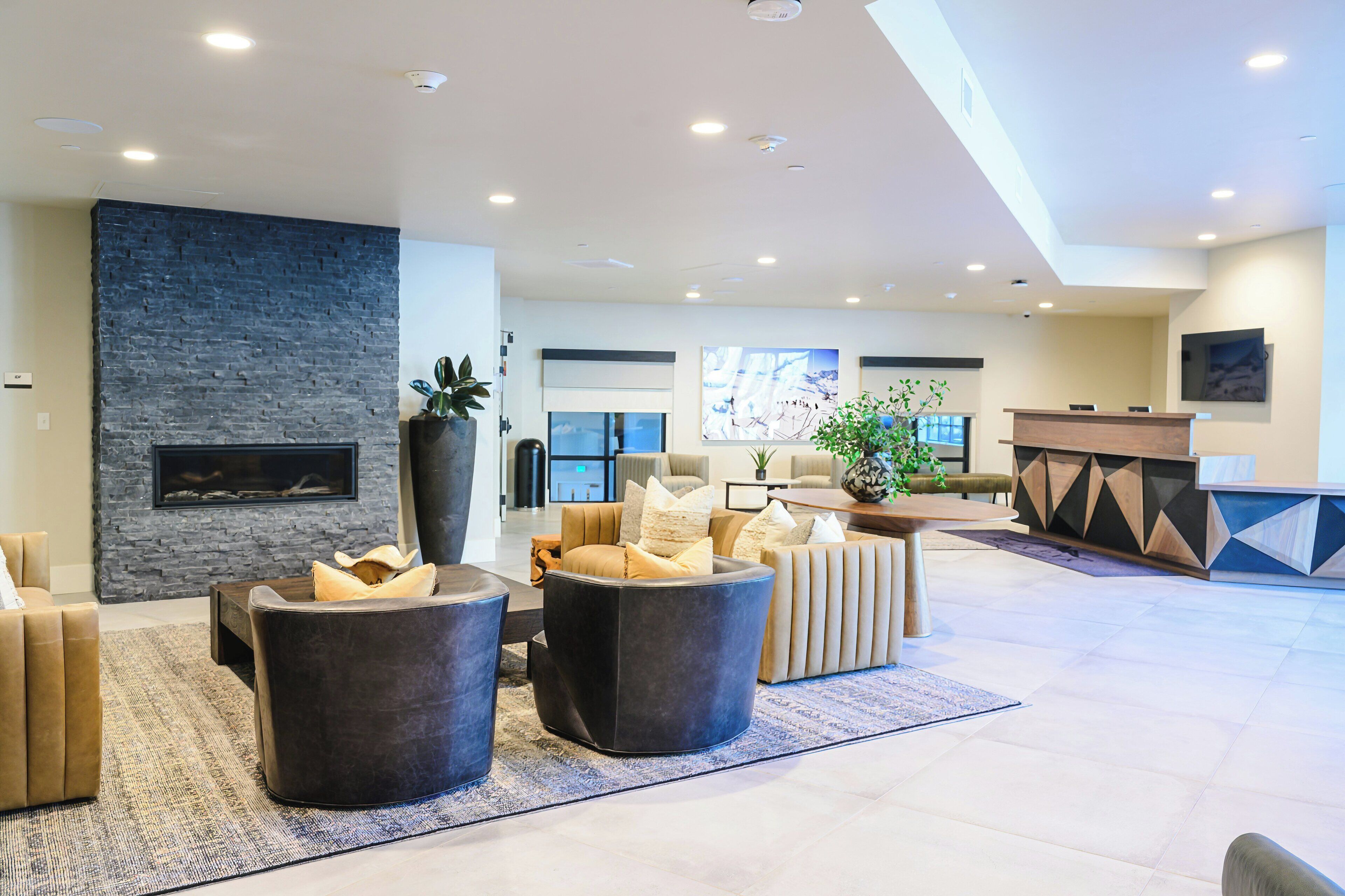 Eine geräumige Lobby mit Kamin aus Stein, Sitzgelegenheiten und einer Rezeption.