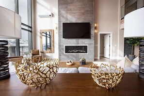 A modern living room with a fireplace, a flat-screen TV, and a large window. - Black Rock Mountain Resort (Heber City)