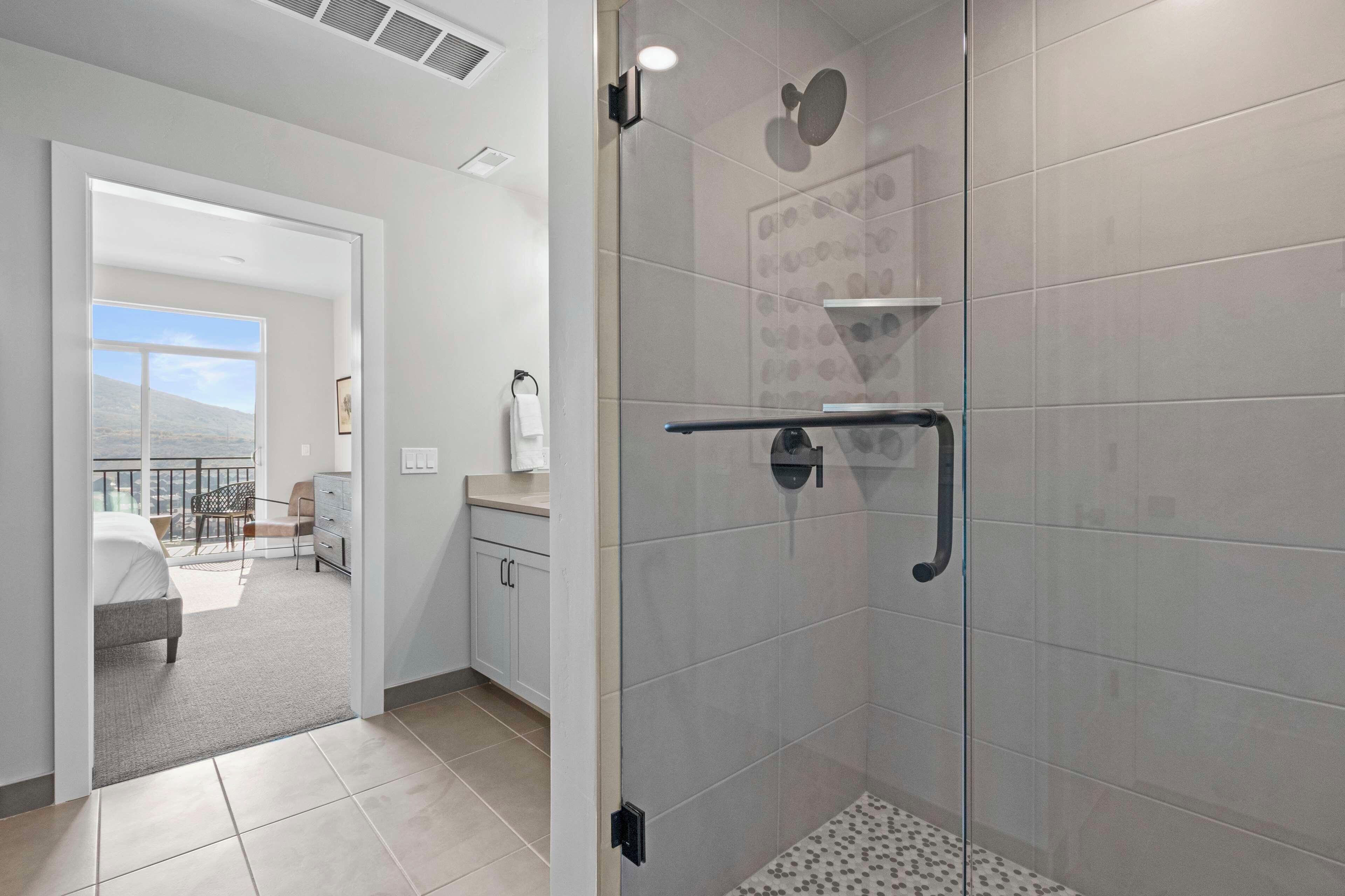 Un baño moderno con cabina de ducha de vidrio, inodoro y lavamanos.
