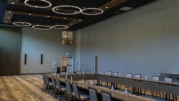 A conference room with a long table, chairs, and a patterned carpet.