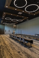 Ein Konferenzraum mit langem Tisch, Stühlen und einem gemusterten Teppich.