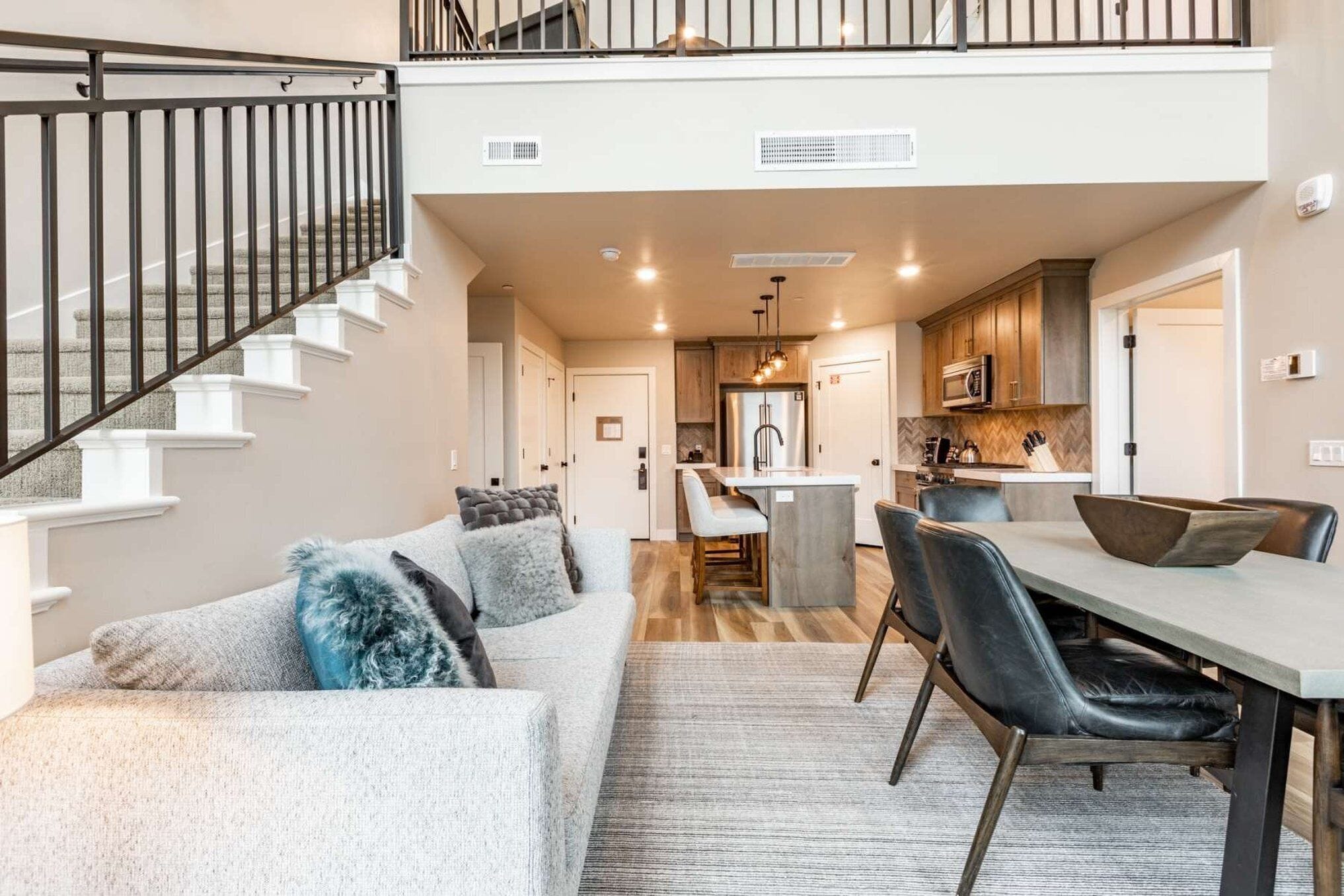 A modern interior with a staircase, a dining area, and a kitchen.