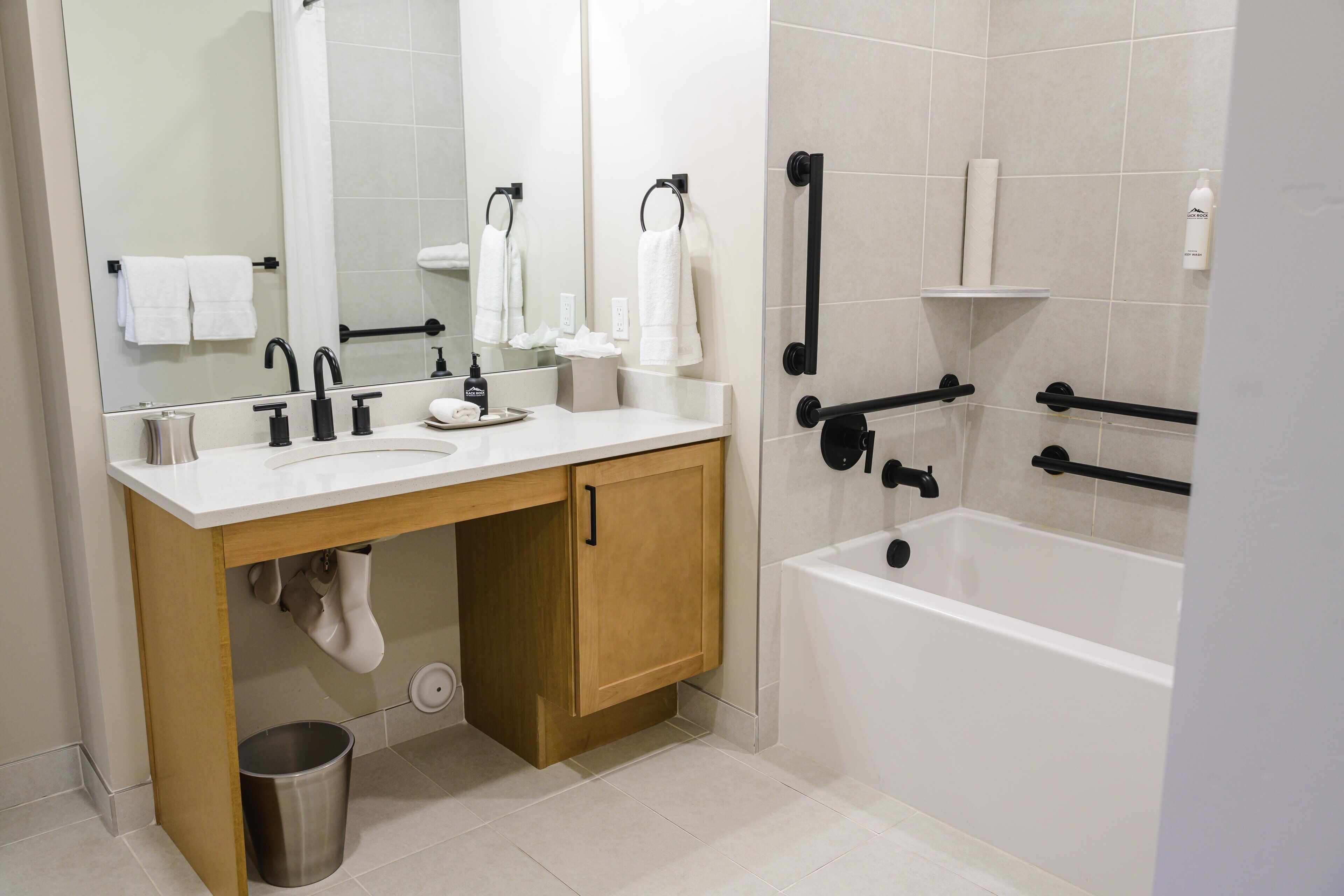 Une salle de bain moderne avec un lavabo, un miroir et une baignoire.
