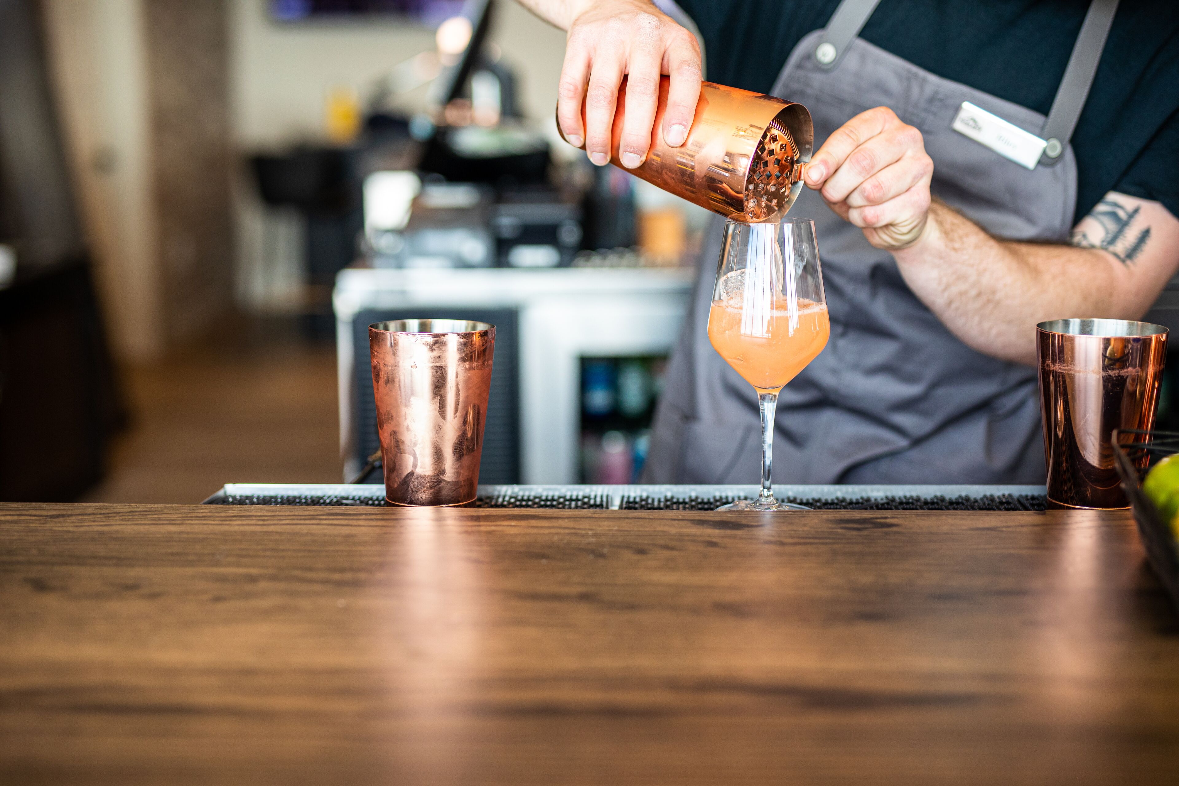 A bartender pouring a drink into a glass.