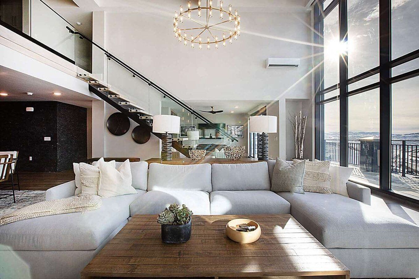 Ein modernes Wohnzimmer mit einem Ecksofa, einem Couchtisch und einem großen Fenster mit Blick.