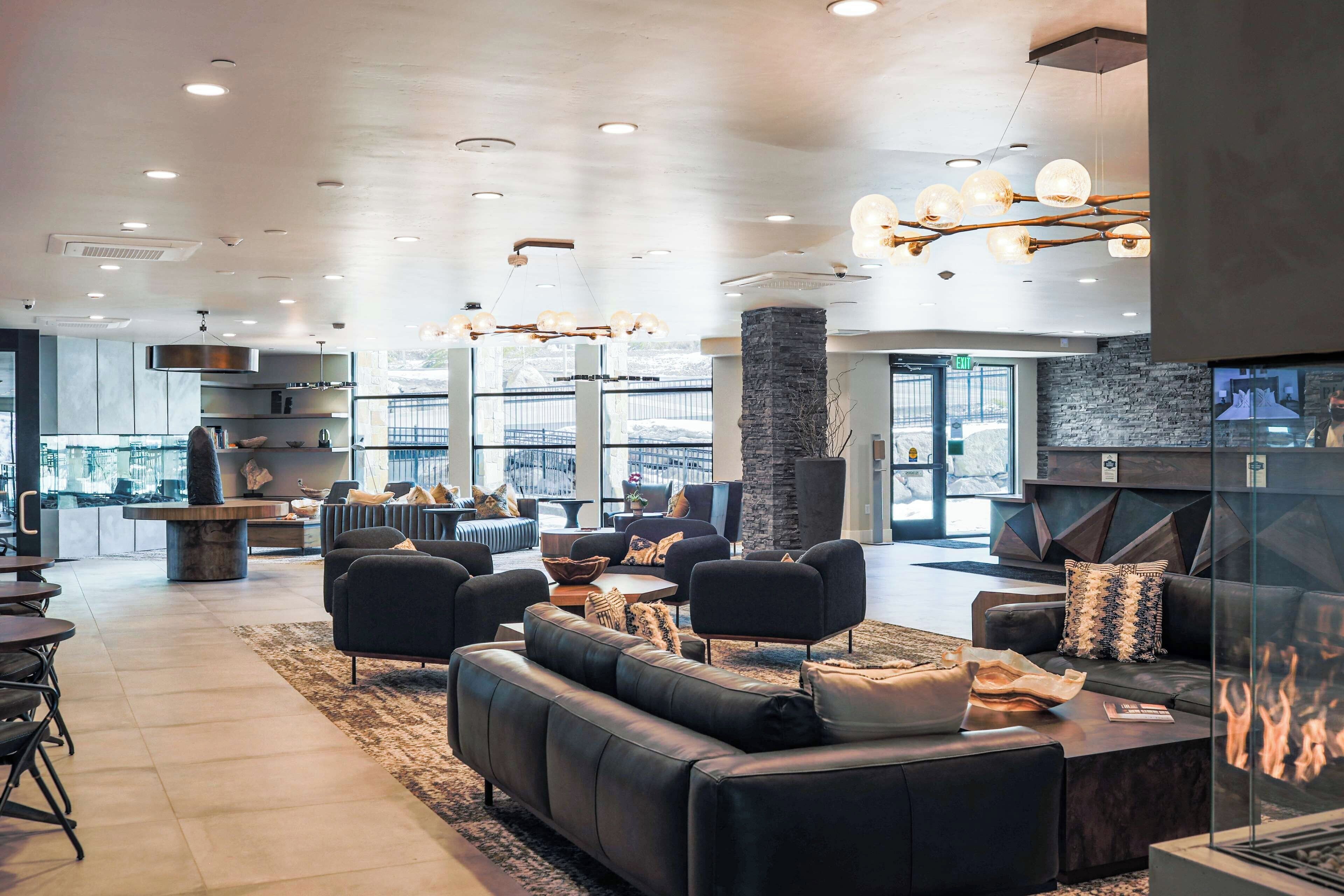 A spacious lobby with a fireplace, comfortable seating, and a view of the outdoors.