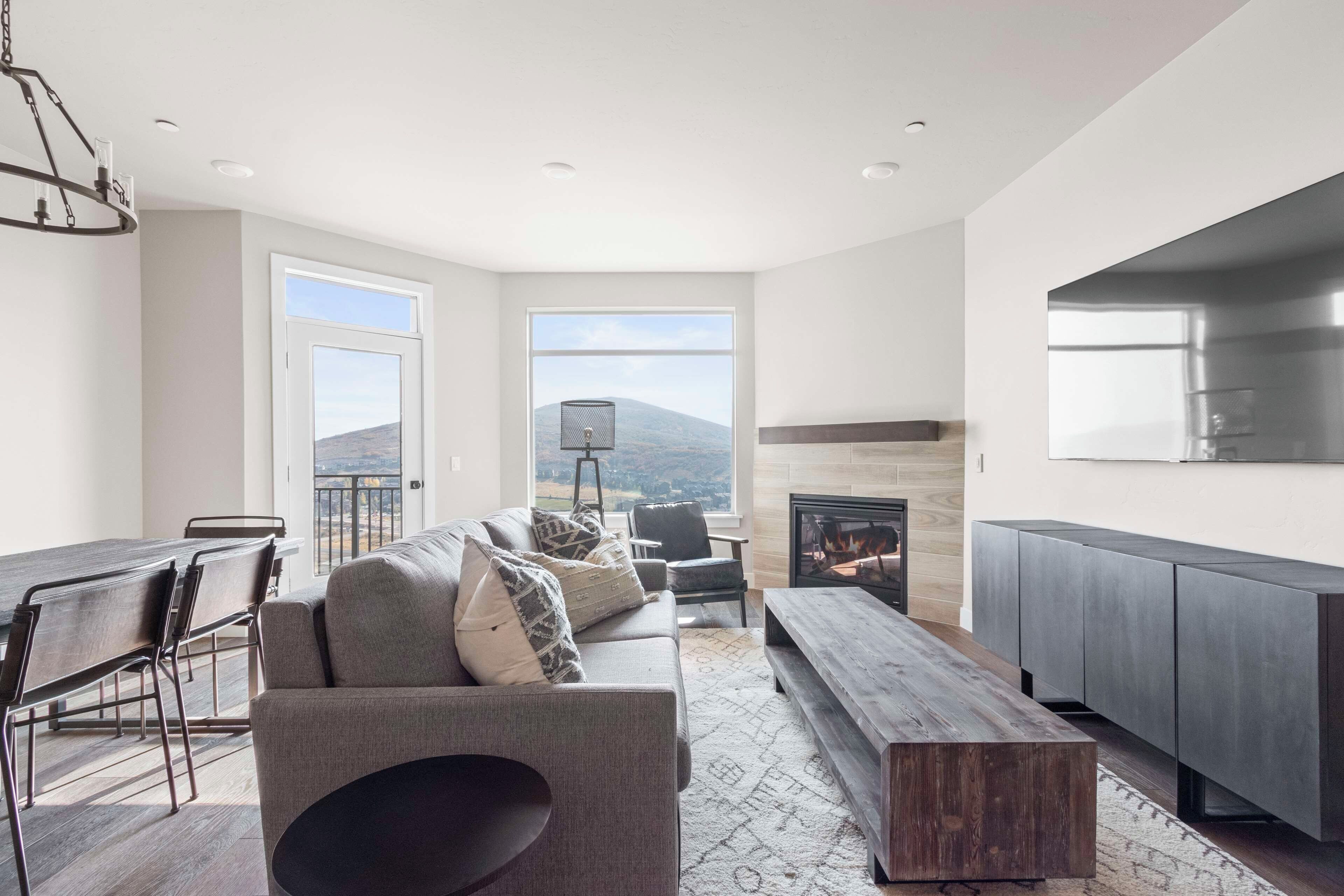 Una sala de estar moderna con sofá, mesa de centro y chimenea.