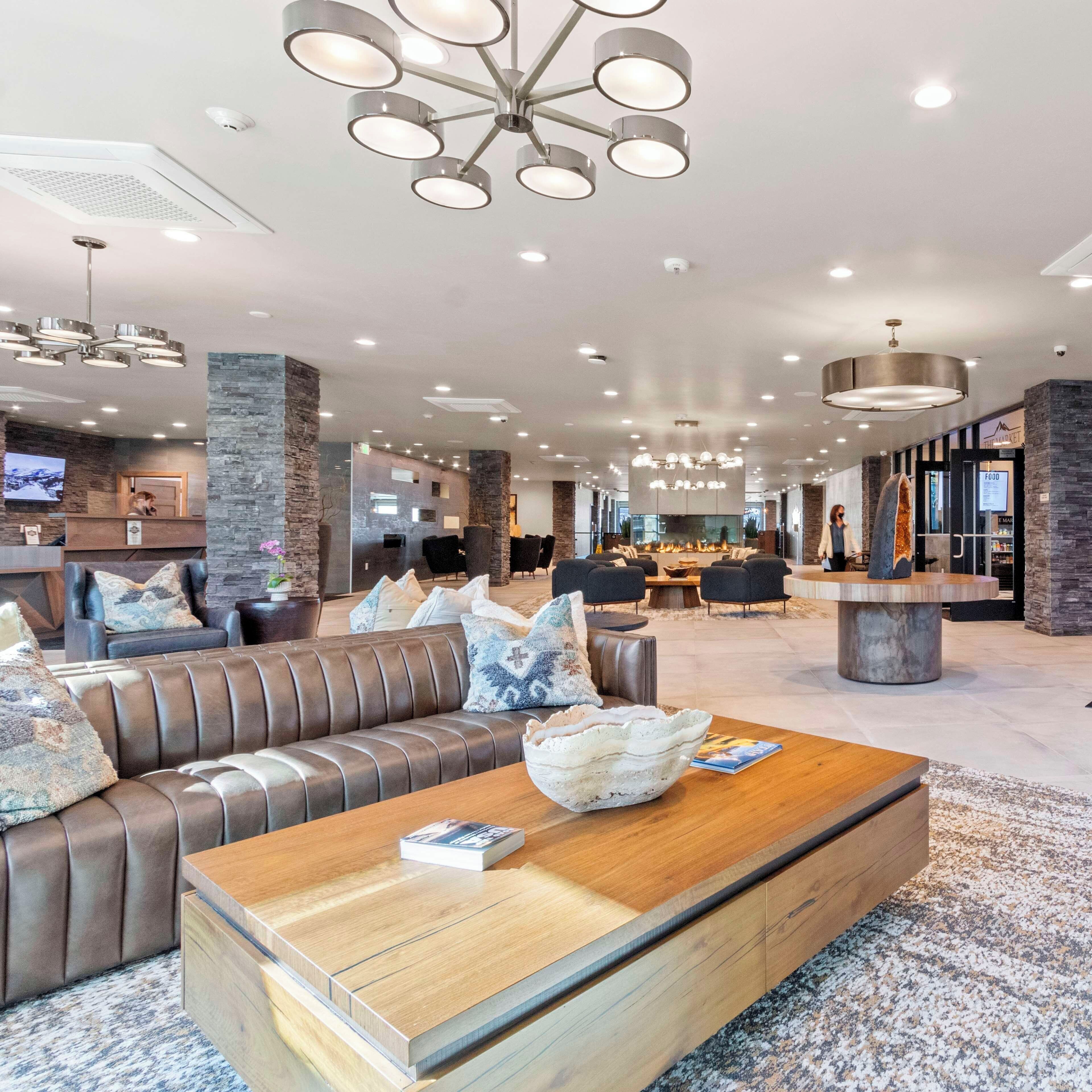 A spacious lobby with a leather sofa, a coffee table, and a fireplace.